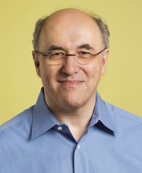 A picture of Stephen Wolfram (wearing glasses and a blue
                      shirt) smiles.