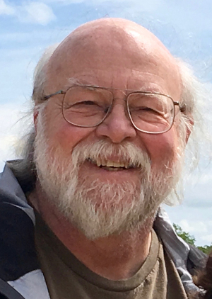 A picture of James Gosling (wearing glasses and with a
                      white beard) smiling in a sunny day.